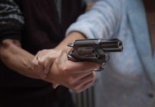 Morde agente e cerca di sottrargli l’arma di ordinanza