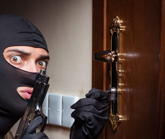 A settembre riprendono discussione e audizioni sulla riforma della legittima difesa rapinatore con passamontagna e pistola davanti a una porta chiusa: riprendono le audizioni sulla riforma della legittima difesa