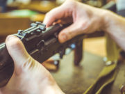 mani di armaiolo che smontano arma: corso licenza armi ed esplodenti di Conarmi