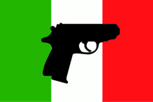 Pistola su bandiera italiana: Fidasc sul recepimento della Direttiva Armi