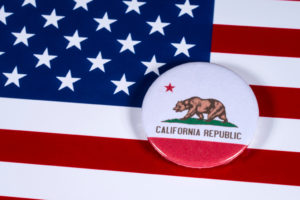 Spilla della California su bandiera americana: la California stringe sul porto di armi occulte