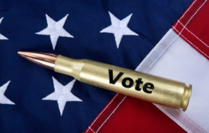 munizione con scritta "vote" su bandiera americana: studio sulla partecipazione politica dei proprietari di armi