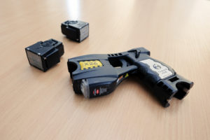 taser con due munizioni su tavolo di legno: possibile l’assegnazione del taser agli agenti di polizia penitenziaria