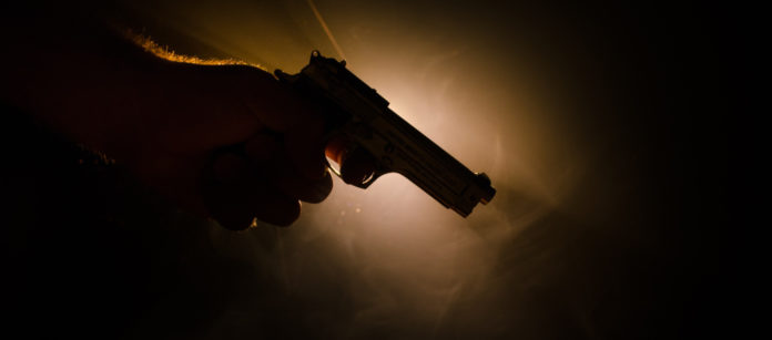 mano che impugna pistola: omicidi commessi con armi legalmente detenute