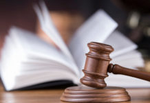 Legittima difesa, i dubbi di magistrati e avvocati legittima difesa: martello del giudice davanti a un codice aperto