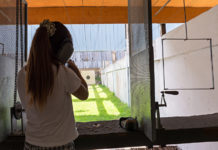 Scaricare dalle tasse la donazione per impianti sportivi: la nota di Uits ragazza di spalle mentre imbraccia arma in un poligono: scaricare dalle tasse la donazione per impianti sportivi