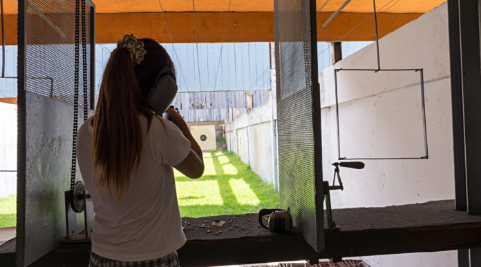 ragazza di spalle mentre imbraccia arma in un poligono: scaricare dalle tasse la donazione per impianti sportivi