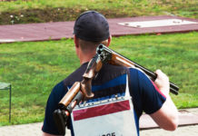 Squadre miste di tiro a volo, cinque nazioni contro l’Issf squadre miste di tiro a volo: tiratore va in posizione con fucile sulle spalle
