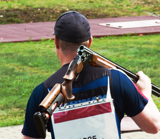 Squadre miste di tiro a volo, cinque nazioni contro l’Issf squadre miste di tiro a volo: tiratore va in posizione con fucile sulle spalle