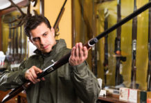 Le leggi sulle armi: un seminario a dicembre leggi sulle armi: venditore di armi in armeria presenta fucile