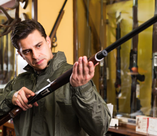 Le leggi sulle armi: un seminario a dicembre leggi sulle armi: venditore di armi in armeria presenta fucile