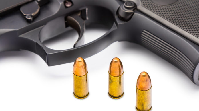 pistole 9 mm in America: tre proiettili calibro 9 mm davanti a una pistola