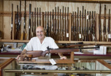 Mercato delle armi in America: prosegue il boom mercato delle armi in America: armiere presenta fucile all'interno di un gunshop americano