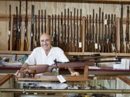 Mercato delle armi in America: prosegue il boom mercato delle armi in America: armiere presenta fucile all'interno di un gunshop americano