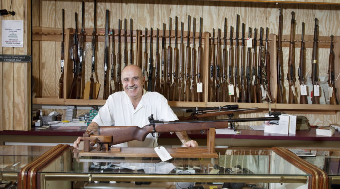 mercato delle armi in America: armiere presenta fucile all'interno di un gunshop americano