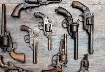 Limite per armi in collezione, Fdi presenta interrogazione al governo licenza per armi in collezione: revolver vintage su un tavolo