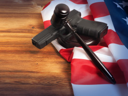 Età minima per acquistare le armi negli Stati Uniti: la sentenza Età minima per acquistare le armi negli Stati Uniti: pistola con bandiera americana e martello del giudice