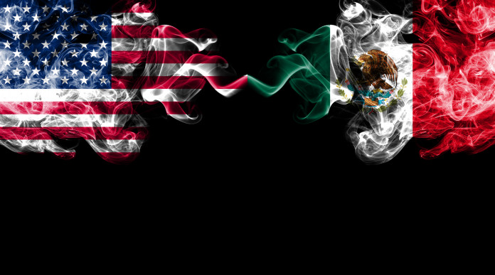 Il governo del Messico fa causa a sette produttori di armi degli Stati Uniti: bandiera di stati uniti e messico come fumo