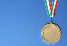 Campionati italiani di tiro a segno: ecco i vincitori Campionati italiani di tiro a segno: medaglia d'oro con bandiera italiana, fondo azzurro