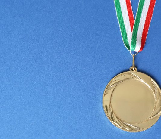 Campionati italiani di tiro a segno: ecco i vincitori Campionati italiani di tiro a segno: medaglia d'oro con bandiera italiana, fondo azzurro