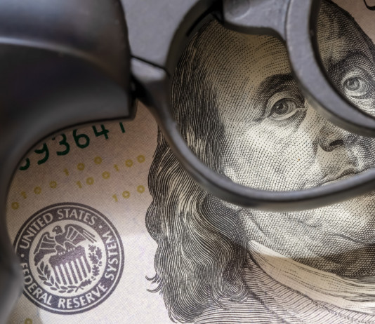 Mercato delle armi in America: gli ultimi dati Mercato delle armi in America: pistola appoggiata su banconota da 100 dollari