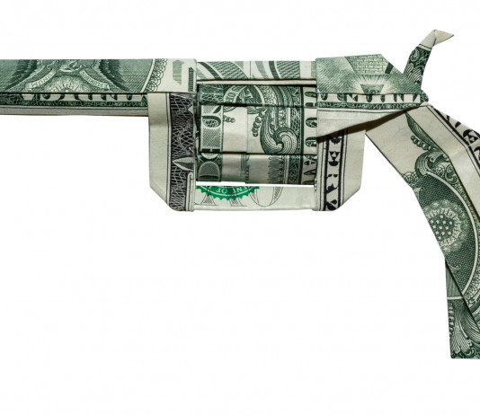 Vendita di armi in America: i numeri di fine 2021 Vendita di armi in America: origami pistola con dollari