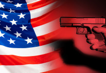 Mercato delle armi in America: i dati a metà aprile 2022 Mercato delle armi in America: pistola impugnata davanti a bandiera americana