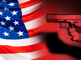 Mercato delle armi in America: i dati a metà aprile 2022 Mercato delle armi in America: pistola impugnata davanti a bandiera americana