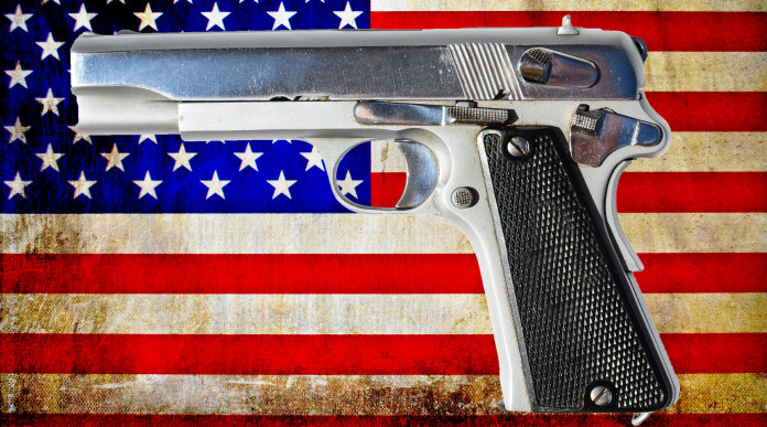 Mercato delle armi in America: pistola su sfondo di bandiera americana