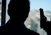 Licenza per uso sportivo e difesa personale: la sentenza Licenza per uso sportivo e difesa personale: uomo davanti alla finestra, di spalle, con pistola in mano