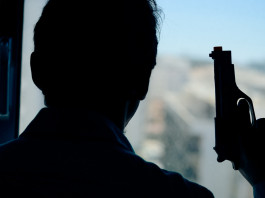 Licenza per uso sportivo e difesa personale: la sentenza Licenza per uso sportivo e difesa personale: uomo davanti alla finestra, di spalle, con pistola in mano