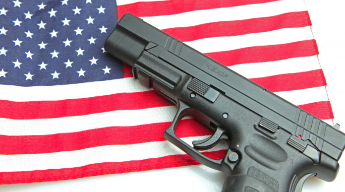 Background check in America: pistola su bandiera americana