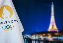 Carte olimpiche per le specialità di tiro: il riepilogo a fine 2022 Carte olimpiche per le specialità di tiro: bandiera Parigi 2024 davanti alla Torre Eiffel di notte