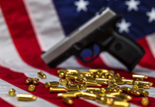 Mercato delle armi in America: la situazione a metà novembre Mercato delle armi in America: pistola e proiettili davanti a bandiera americana