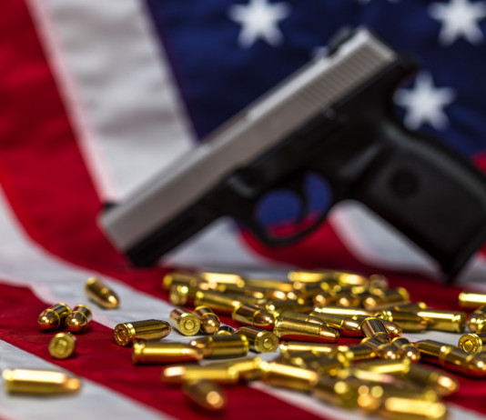 Mercato delle armi in America: la situazione a metà novembre Mercato delle armi in America: pistola e proiettili davanti a bandiera americana