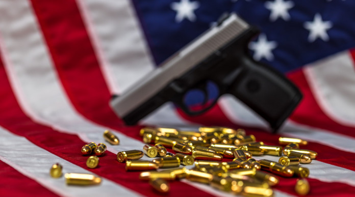 Mercato delle armi in America: pistola e proiettili davanti a bandiera americana