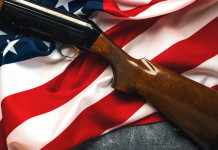 Vendita di armi in America: la situazione a fine ottobre Vendita di armi in America: fucile con calcio in legno su bandiera americana