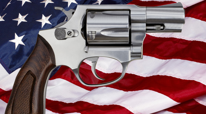 Mercato delle armi in America: revolver davanti a bandiera americana