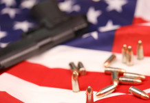 Mercato delle armi in America: la situazione a metà dicembre Mercato delle armi in America: pistola con munizioni su bandiera americana