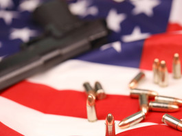 Mercato delle armi in America: la situazione a metà dicembre Mercato delle armi in America: pistola con munizioni su bandiera americana