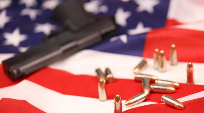 Mercato delle armi in America: pistola con munizioni su bandiera americana