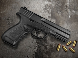 Porto d’armi per difesa personale: ultimo appello Porto d’armi per difesa personale: pistola con proiettili appoggiata su cemento