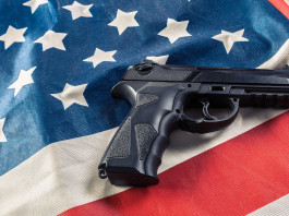 Mercato delle armi in America: i numeri a inizio 2023 Mercato delle armi in America: pistola su bandiera americana