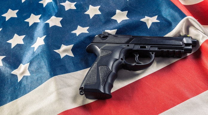 Mercato delle armi in America: pistola su bandiera americana