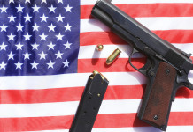 Mercato delle armi in America: i dati a metà marzo Mercato delle armi in America: pistola su bandiera americana con caricatore