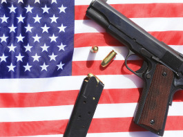 Mercato delle armi in America: i dati a metà marzo Mercato delle armi in America: pistola su bandiera americana con caricatore