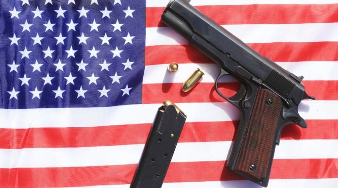 Mercato delle armi in America: pistola su bandiera americana con caricatore