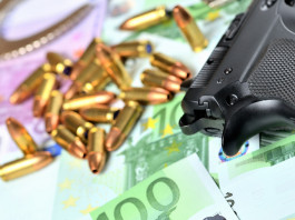 Valore economico del settore armiero in Italia: lo studio Valore economico del settore armiero in Italia: pistola con munizioni e banconote in euro