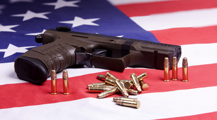 Background check in America: pistola con munizioni su bandiera americana