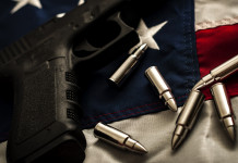 Background check in America: la situazione a fine aprile Background check in America: pistola con proiettili e bandiera americana